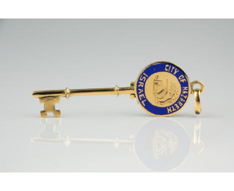 An 18ct gold and enamel City of Nazareth pendent in the form of a key, 5cm. long, in the original olive wood box inscribed 'N