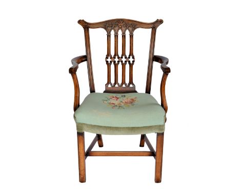 A 19th century Chippendale style mahogany elbow chair, the yoke form top rail with carved foliage and fleur-de-lys, over a Go