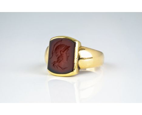 A 19th century 18ct gold and carnelian intaglio seal signet ring, the seal with intaglio bust of a Greek warrior, on a domed,