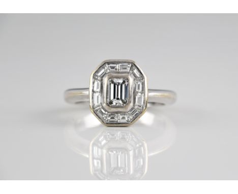 An 18ct white gold and diamond Art Deco style cluster ring, the central approx. 0.25ct emerald cut diamond within an octagona