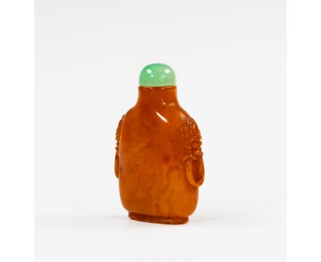 A Chinese egg yolk amber snuff bottle, 18th / 19th century, rounded straight sided form, relief carved taotie mask and ring h