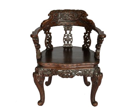 A Chinese carved and stained wooden dragon armchair, c.1900, the shaped top rail carved with a dragon amidst clouds, over cur