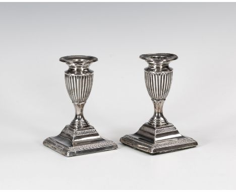 A pair of late-Victorian dwarf silver candlesticks, I. S. Greenberg & Co. (Israel Sigmund), Sheffield 1900, the stepped squar