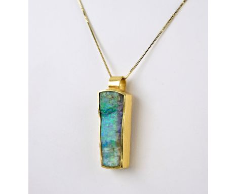 An unusual 18ct yellow gold and opal pendant, the 20ct tapered, boulder opal in a brushed gold rubover setting, 3.9cm. long o