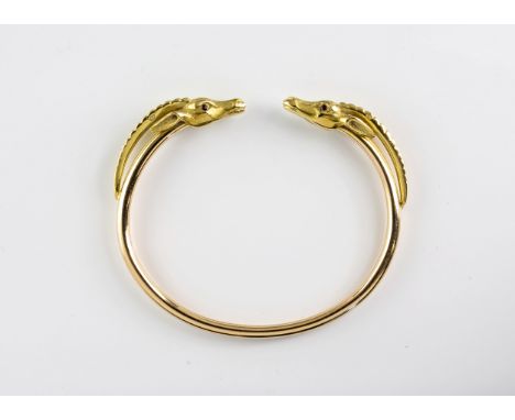 A vintage 18ct yellow gold Sable/deer head torque bangle by Gay Freres, the realistic textured heads each set with ruby eyes.