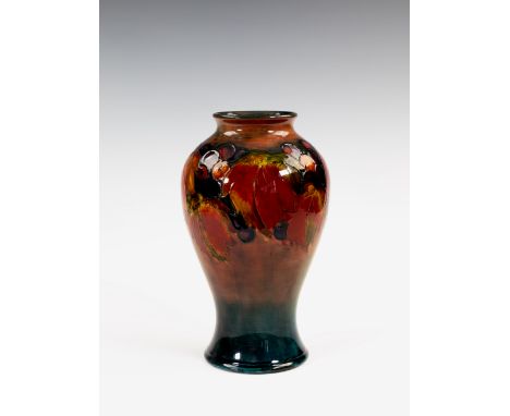 A Moorcroft flambé glazed vase, 1930s, of inverted baluster form, decorated in the Leaves and Fruit pattern on a graduated fl