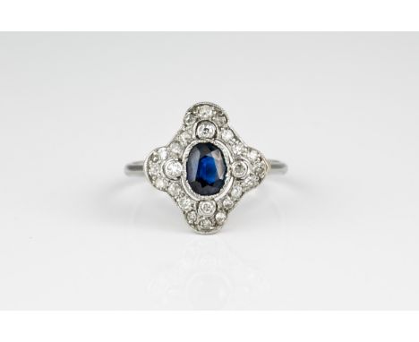 A mid-century platinum, sapphire and diamond Art Deco style cluster ring, the central oval cut sapphire within a pierced quat