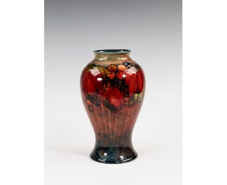 A Moorcroft flambé glazed vase, 1930s, of inverted baluster form, decorated in the Leaves and Fruit pattern on a graduated fl