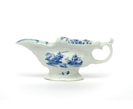 A large Worcester blue and white sauceboat  c.1755, the high-footed body moulded with foliate cartouches and painted with the