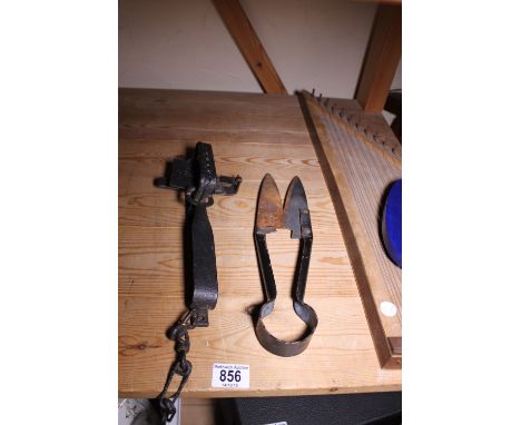Vintage cast metal sheep shearer and gin trap