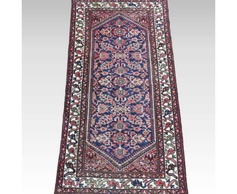 A Persian carpet, with a central floral panel, within an ivory border, 290 x 150cm