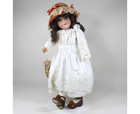 An Armand Marseille bisque head doll, marked 390n, A9M, dressed in old clothes, hat and shoes, 61cm high, on standHead cracke
