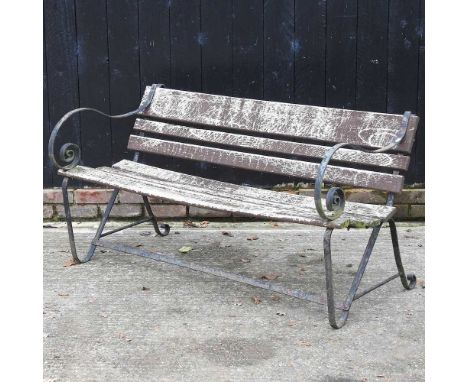 A wrought iron garden bench, with scrolled arms and wooden slatted seat143w x 75d x 76h cm