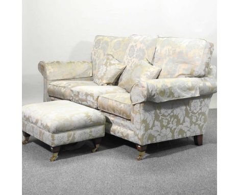 A modern blue floral upholstered three seater sofa, on turned legs, together with a matching footstool and part roll of match