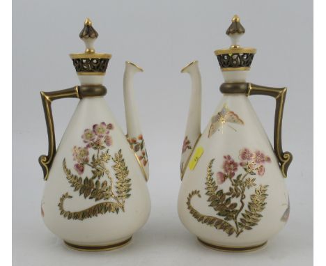 A pair of Royal Worcester Persian style gilt ivory ewers, with stoppers and pierced necks, decorated with flowers and insects