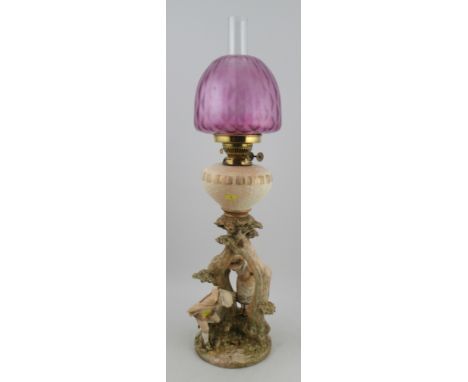 A Royal Worcester blush ivory oil lamp, modelled with Kate Greenaway figures shape No. 1240, with associated pink glass shade