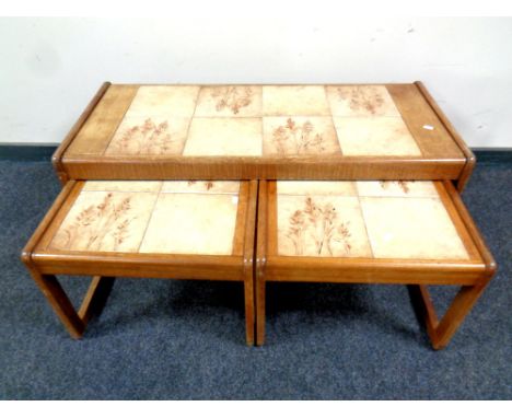 A 20th century nest of teak and tile topped tables, width 105 cm 