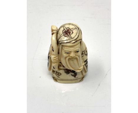 A Japanese carved bone netsuke - Village elder holding a scroll. 