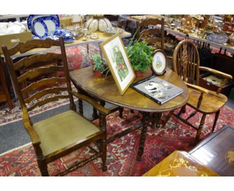 An oak barley twist gate leg dining table, two oak ladder back carver chairs; a wheel back carver (4)
