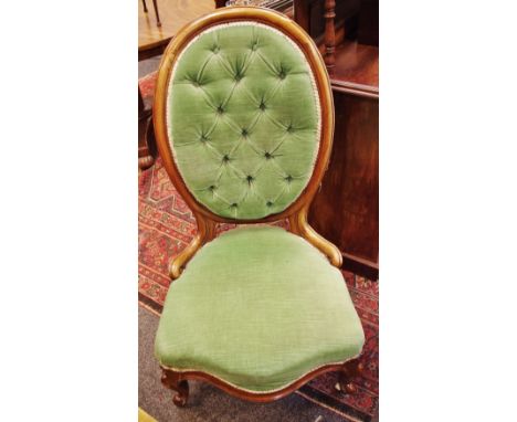 A Victorian mahogany spoon back nursing chair, button upholstered back, serpentine padded seat, knurled feet, ceramic casters