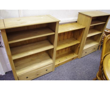 A pair of modern pine three shelf bookcases with long drawer to base; another smaller two shelf. (3)