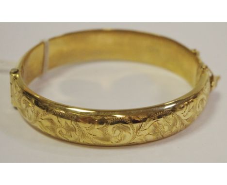 A 9ct gold hinged bangle engraved with scrolls &amp; foliage, Ronex, Birmingham 19.7g