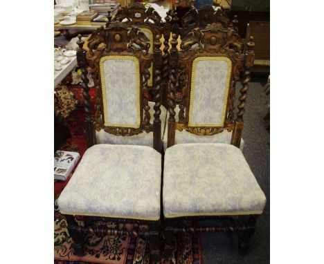 A set of four oak Carolean revival dining chairs surmounted with griffin armorial's, bobbin turned with carved scrolling  aca