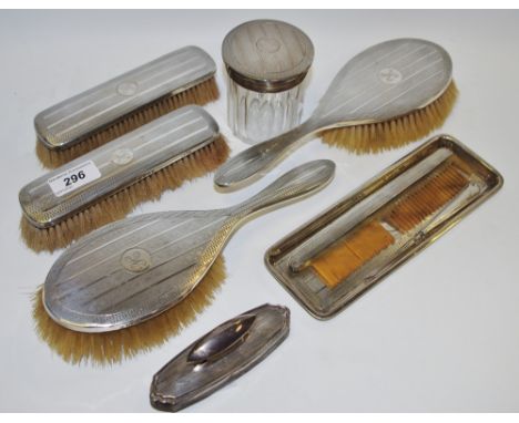 A silver dressing table set, engine and initialled, comprising, brushes, jars, tray and butter hook etc, Birmingham 