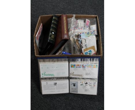 A box of three files of first day covers, stamp collecting books and a quantity of loose stamps 