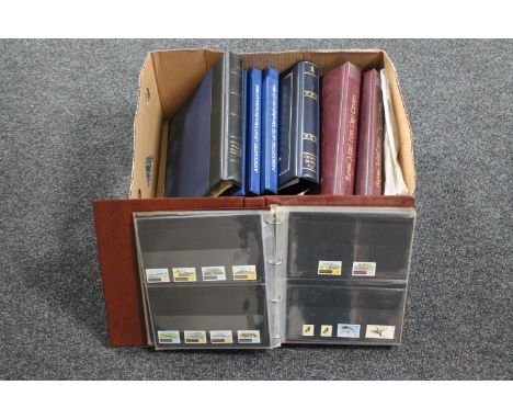 A box of eight folders of Royal Mail presentation packs and first day covers, Stanley Gibbons stamp collecting books and a qu