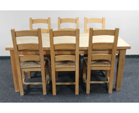 A light pine farmhouse dining room table and six ladder back chairs 