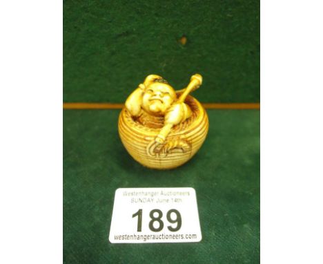 Ivory Netsuke of a Happy Buddha seated within a wicker basket,