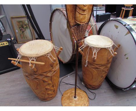 A pair of tiki drums together with standard lamp 