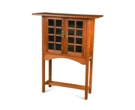 the over scale rectangular top over a pair of glazed doors with single shelf within raised on square legs united by double st