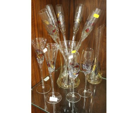 A COLLECTION OF ART GLASS DRINKING FLUTES IN A VASE , WINE GLASSES AND A CARAFE 