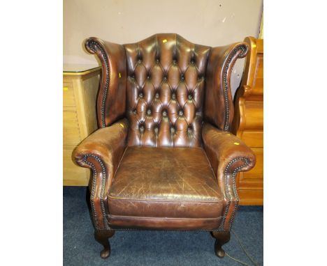 A VINTAGE BROWN LEATHER WINGBACK ARMCHAIR