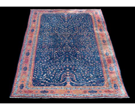 A Tabriz carpet, the navy field decorated with opposing flowering urns, the ochre border with polychrome tablet motifs contai
