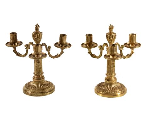 A pair of fine Louis XVI ormolu three light candelabra, late 18th century, the fluted cylindrical sockets on circular drip pa