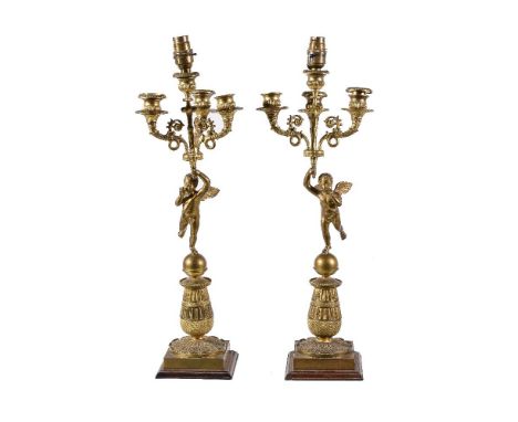 A pair of Empire gilt bronze four light figural candelabra, early 19th century, each with a Campana urn socket raised above t