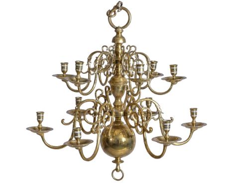 An English or Dutch brass twelve light chandelier, first quarter 18th century, the sockets  and dished drip pans arranged in 