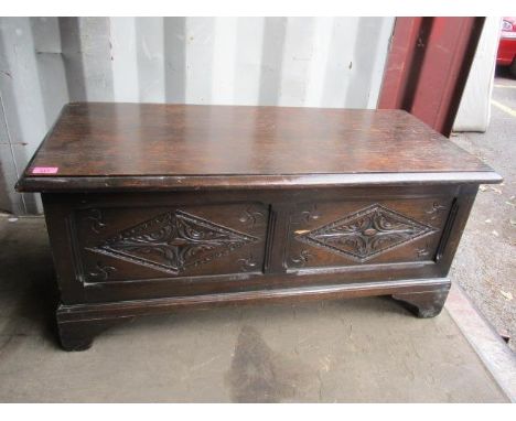 A 1930s oak coffer having a carved front, standing on bracket feet, 17 1/4" h x 37 1/2" w 