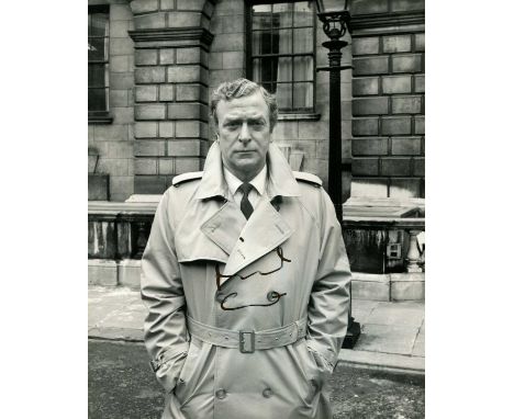 CAINE MICHAEL: (1933- ) English actor, Academy Award winner. Signed 8 x 10 photograph of Caine standing outdoors in a three-q