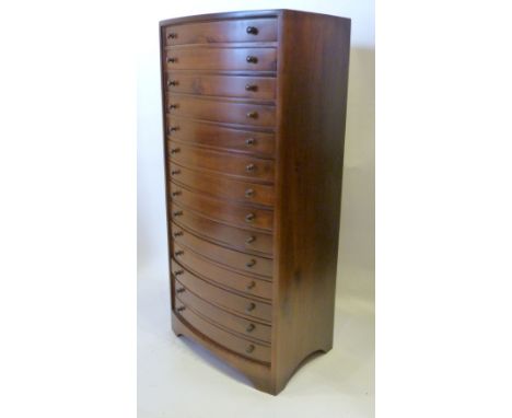 A Hardwood Bow Fronted Collectors' Chest of fourteen drawers with knob handles raised upon bracket feet, 92 cms tall