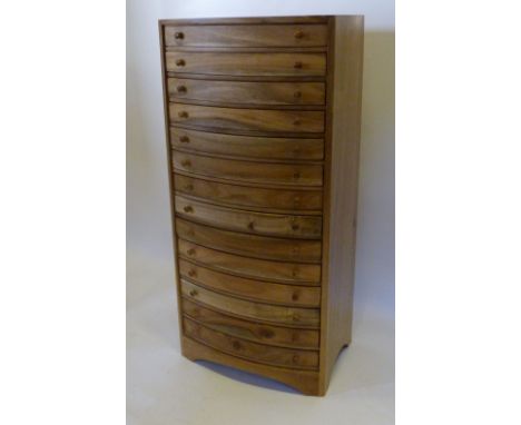 A Hardwood Bow Fronted Collectors' Chest of fourteen drawers with knob handles, 92 cms tall