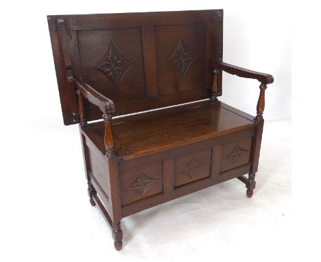 A mid-20th century oak monk's bench, with rising seat and carved panels, W107cm, H81cm, D56cm 