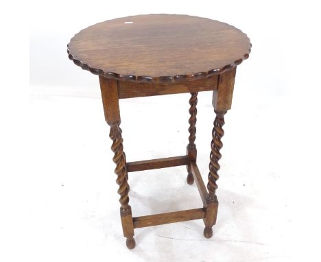 A circular oak lamp table, with shaped edge, on barley twist legs, W50cm, H71cm 