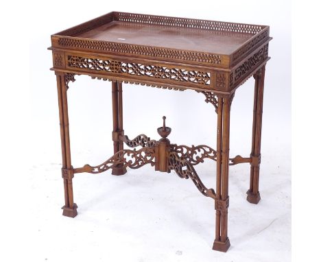 A reproduction mahogany silver table in Chippendale style, with a carved and pierced frieze cross stretcher, and cluster colu