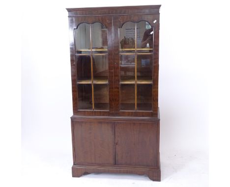 A mahogany bookcase with 2 double arch-top lattice glazed doors, and cupboards under with bracket feet, W79cm, H154cm, D41cm 