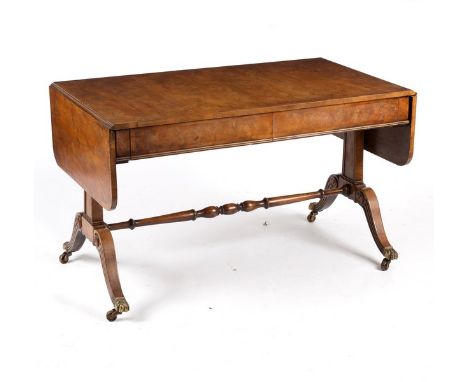 A Regency style yew wood sofa table, the crossbanded top above two frieze drawers on end supports with outswept legs on brass