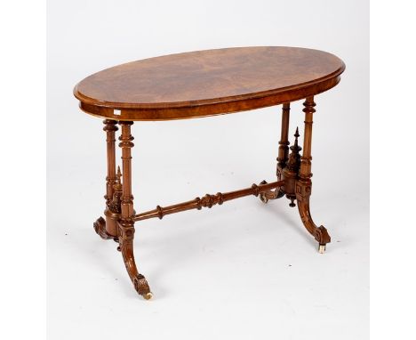 A Victorian burr walnut centre table, the oval top on turned supports and outswept legs with ceramic castors, 108cm wide